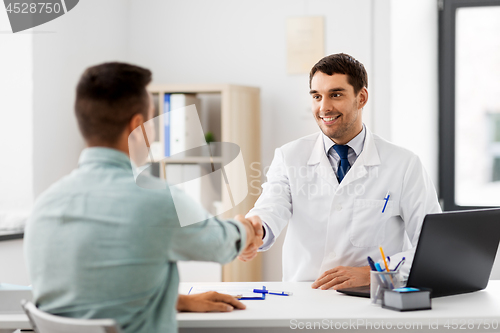 Image of doctor and male patient shaking hands at hospital