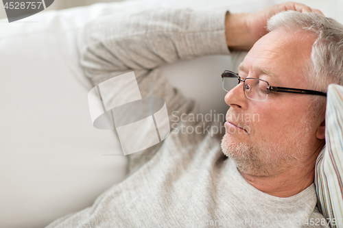 Image of senior man sleeping on sofa at home