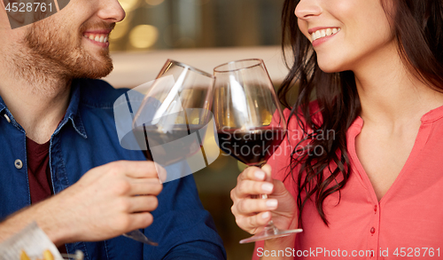 Image of happy couple drinking red wine at restaurant