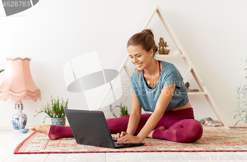 Image of woman with laptop computer at yoga studio