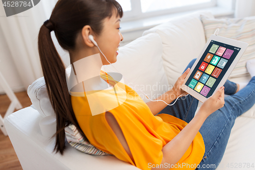 Image of asian woman with smart home icons on tablet screen