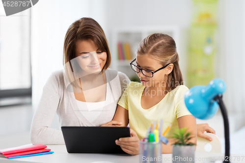 Image of mother and daughter with tablet pc doing homework