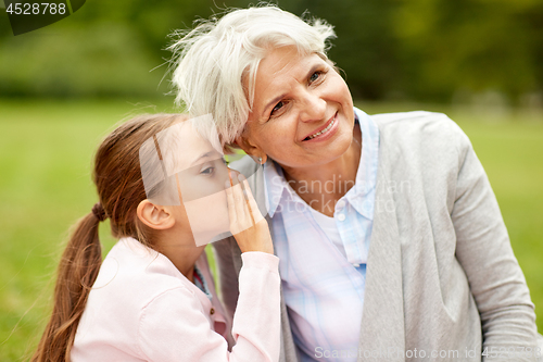 Image of granddaughter sharing secrets with grandmother