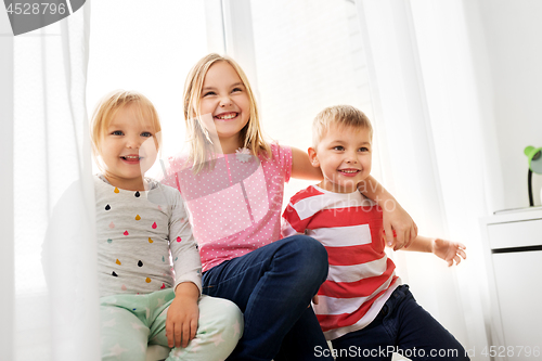 Image of happy little kids hugging at window