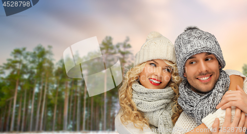 Image of couple hugging over winter forest background