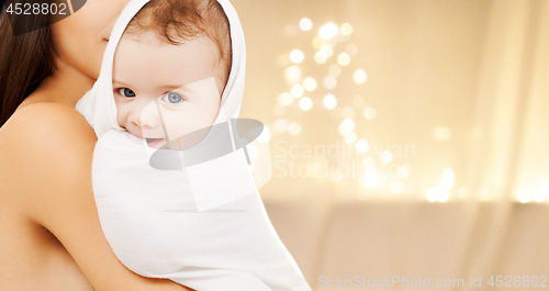 Image of close up of mother with baby over christmas lights