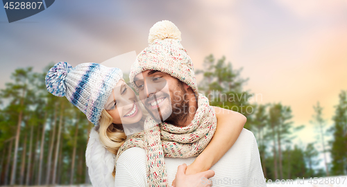 Image of couple hugging over winter forest background