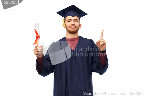 Image of male graduate student in mortar board with diploma