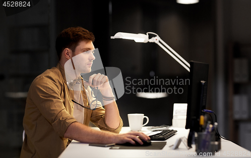 Image of man with computer working late at night office