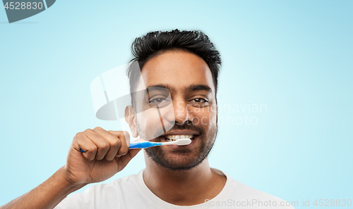 Image of indian man with toothbrush cleaning teeth