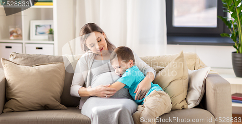 Image of happy pregnant mother and son hugging at home