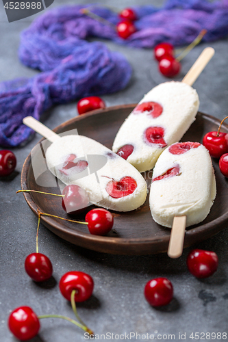 Image of Artisanal vanilla sundae with red cherry.