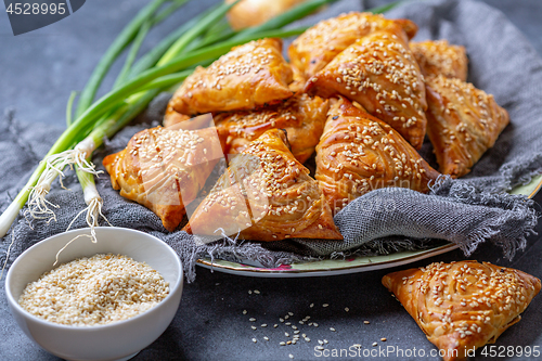 Image of Homemade samosas sprinkled with sesame seeds.