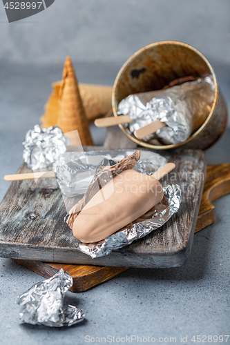 Image of Homemade ice cream with chocolate icing on a stick.