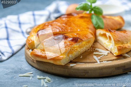 Image of Cut closed pie with cheese and egg (khachapuri).