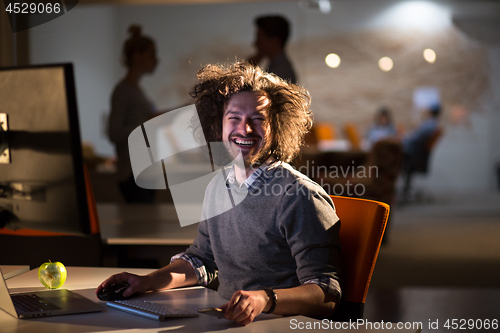 Image of man working on computer in dark office