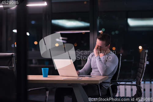 Image of man working on laptop in dark office