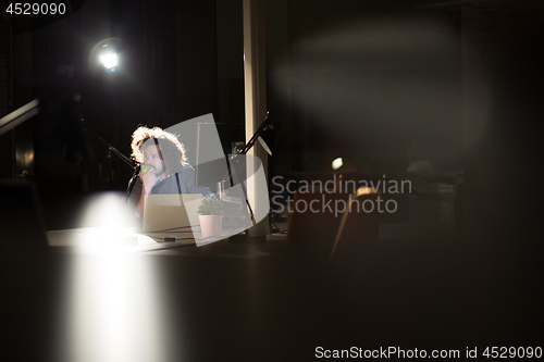 Image of man working on computer in dark office