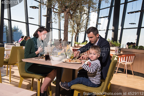 Image of Young parents enjoying lunch time with their children