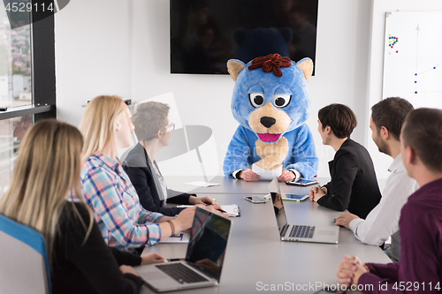 Image of boss dresed as bear having fun with business people in trendy of