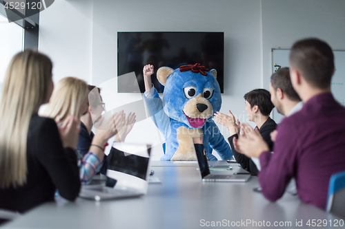 Image of boss dresed as bear having fun with business people in trendy of