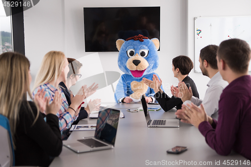 Image of boss dresed as bear having fun with business people in trendy of