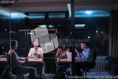 Image of Multiethnic startup business team in night office