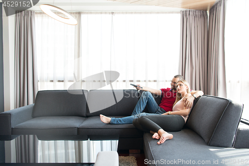 Image of Young couple on the sofa watching television