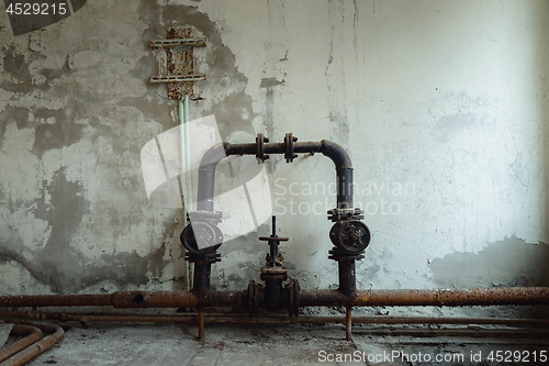 Image of Old water pipes against abandoned wall