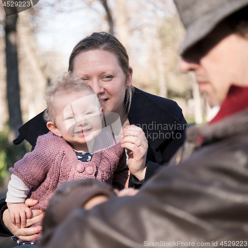 Image of Young family with cheerful child in the park.