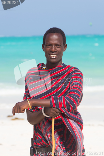 Image of Traditonaly dressed maasai black man on picture perfect tropical Paje beach, Zanzibar, Tanzania, East Africa.