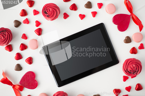 Image of close up of tablet pc and sweets on valentines day