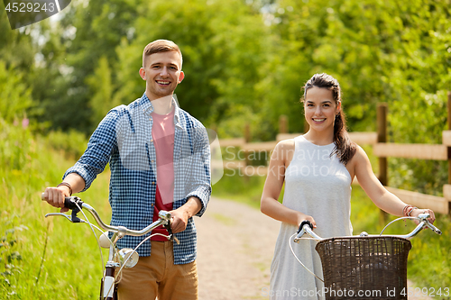 Image of happy couple with bicycles at summer park