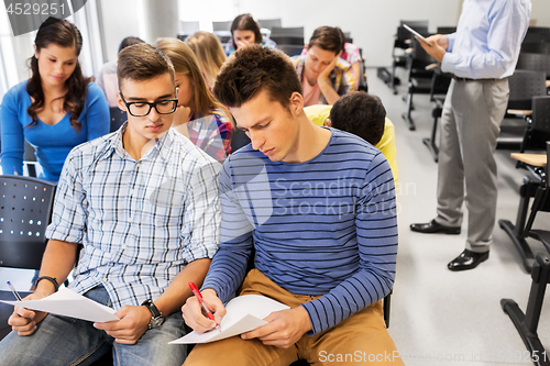 Image of group of students with papers in lecture hall