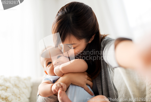 Image of happy mother with little baby son taking selfie