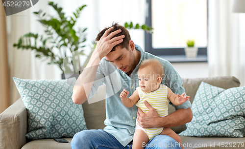 Image of despaired father with little baby daughter at home