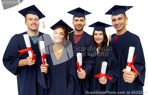 Image of graduates in mortar boards with diplomas