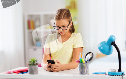 Image of student girl with smartphone doing homework