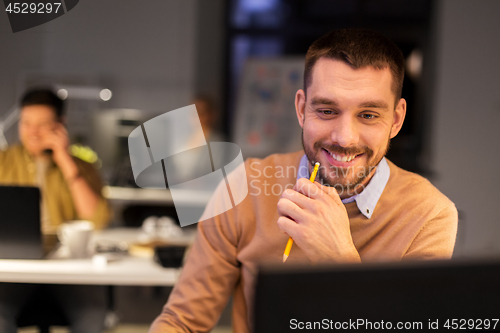 Image of man with computer working late at night office