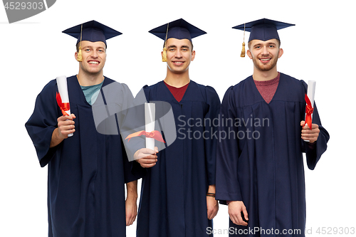 Image of male graduates in mortar boards with diplomas