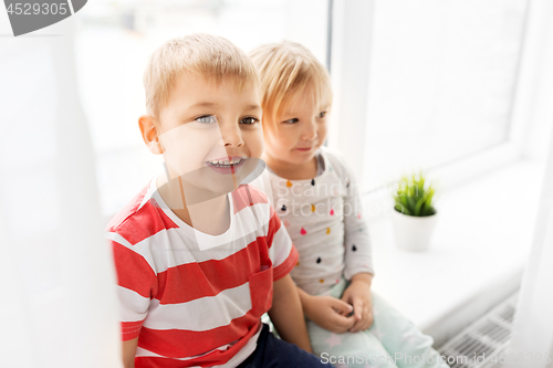 Image of happy little kids sitting on window sill