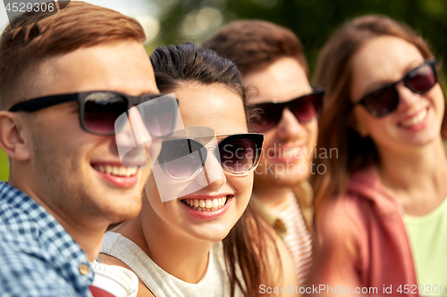 Image of happy teenage friends in sunglasses outdoors