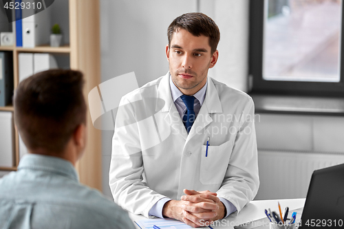 Image of doctor listening to male patient at hospital