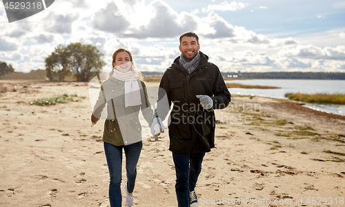 Image of couple walking along autumn beach