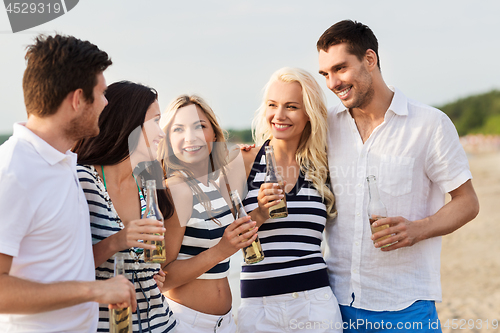 Image of happy friends drinking non alcoholic beer on beach