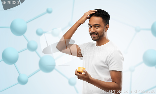 Image of indian man applying hair wax or styling gel