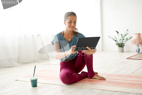 Image of woman with tablet pc and drink at yoga studio