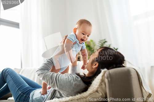 Image of happy mother with little baby son at home