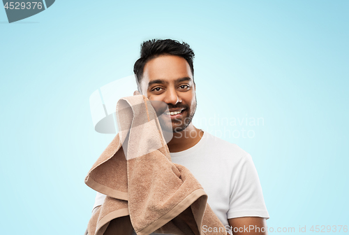 Image of smiling indian man with towel over blue background