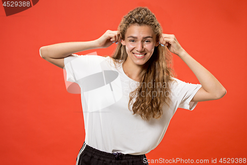 Image of The happy woman standing and smiling against red background.